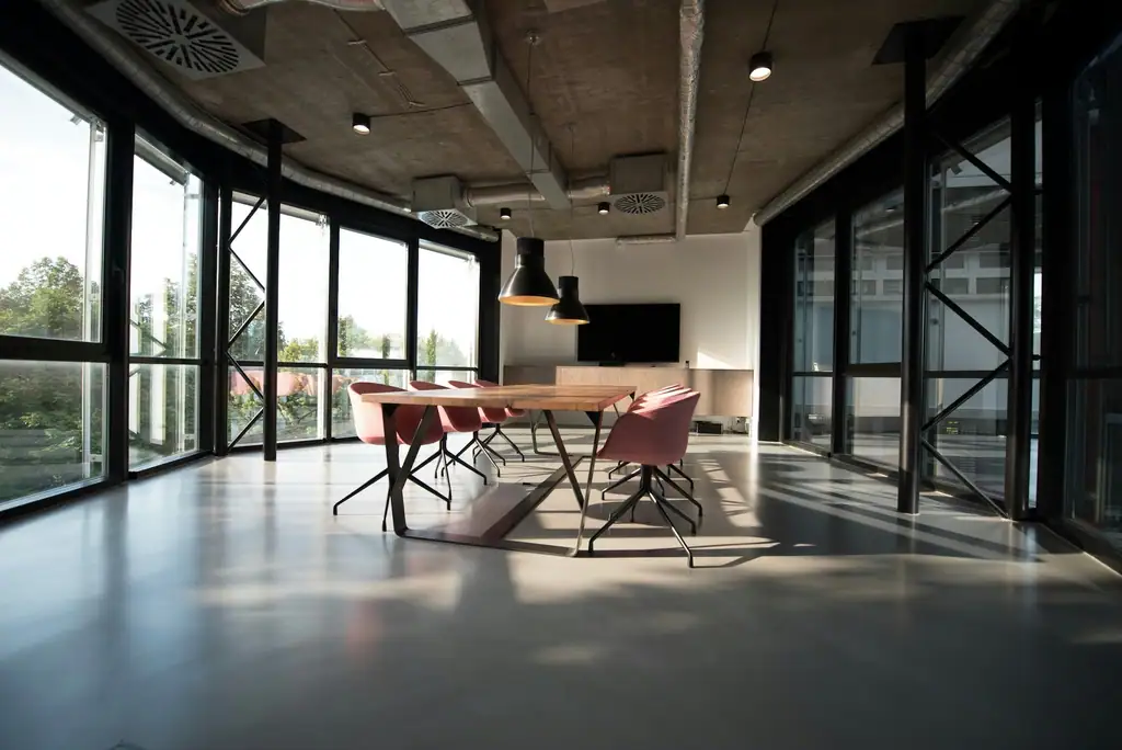 Open-plan office with a long meeting table and floor-to-ceiling windows